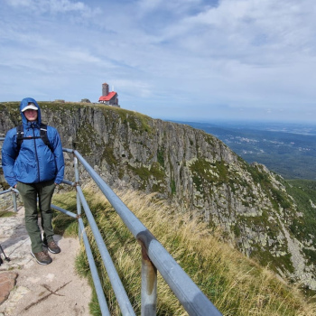 Šimon hrdinně stojí na vrcholu zdolané hory